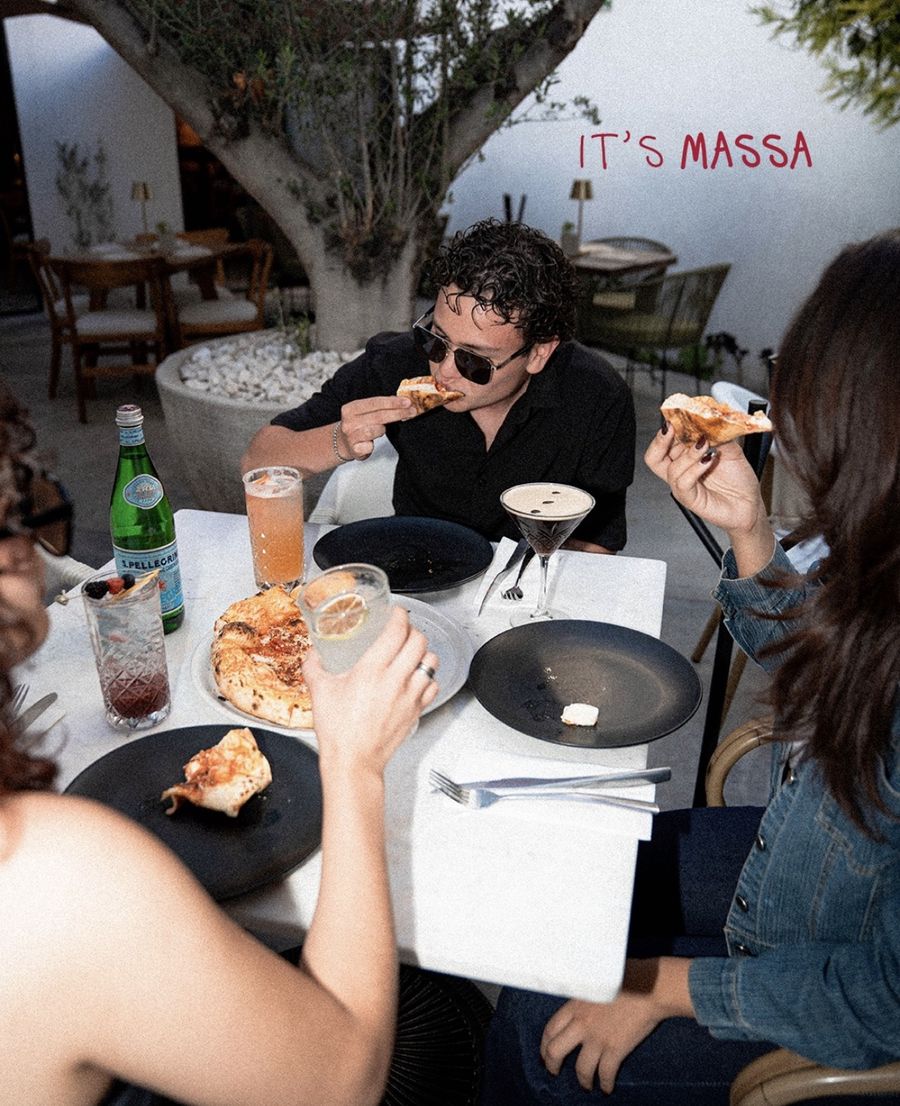 Amigos compartiendo pizza en una mesa de la terraza